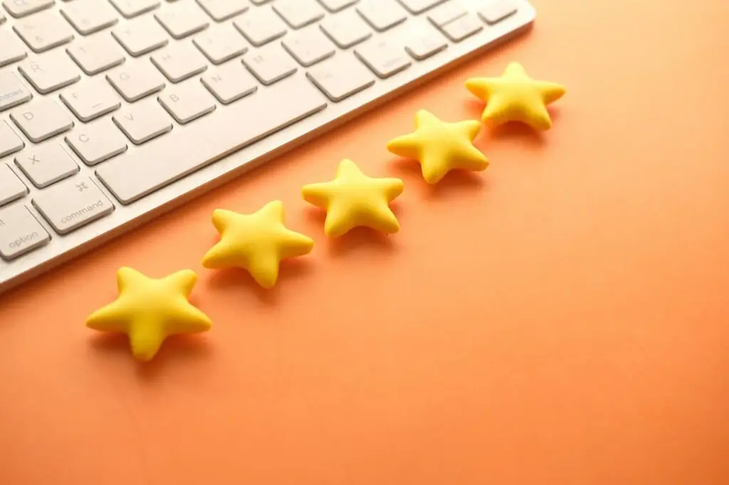 Customer reviews concept. Rating golden stars on orange background